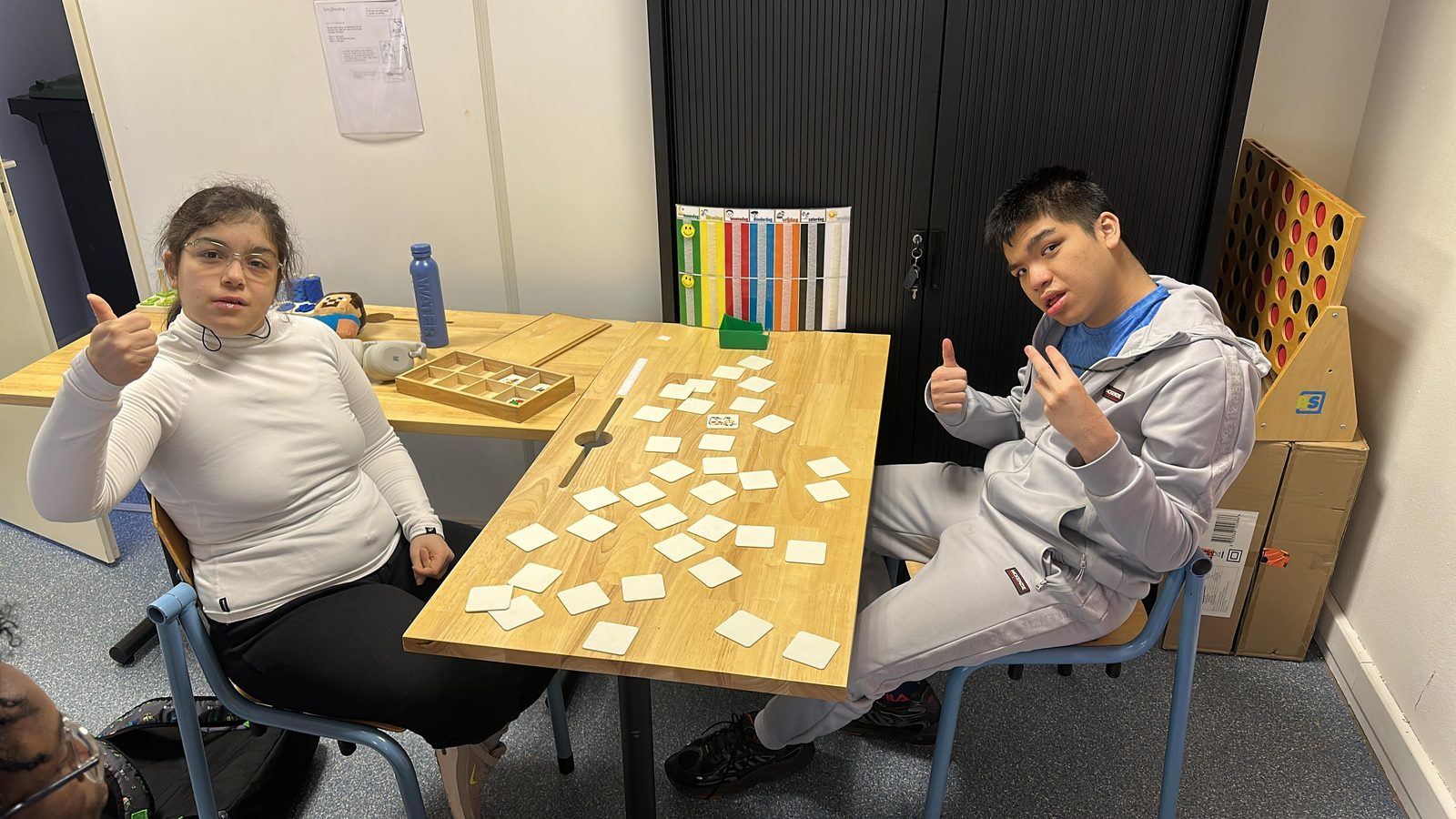 Twee talenten spelen samen een geheugenspel aan tafel